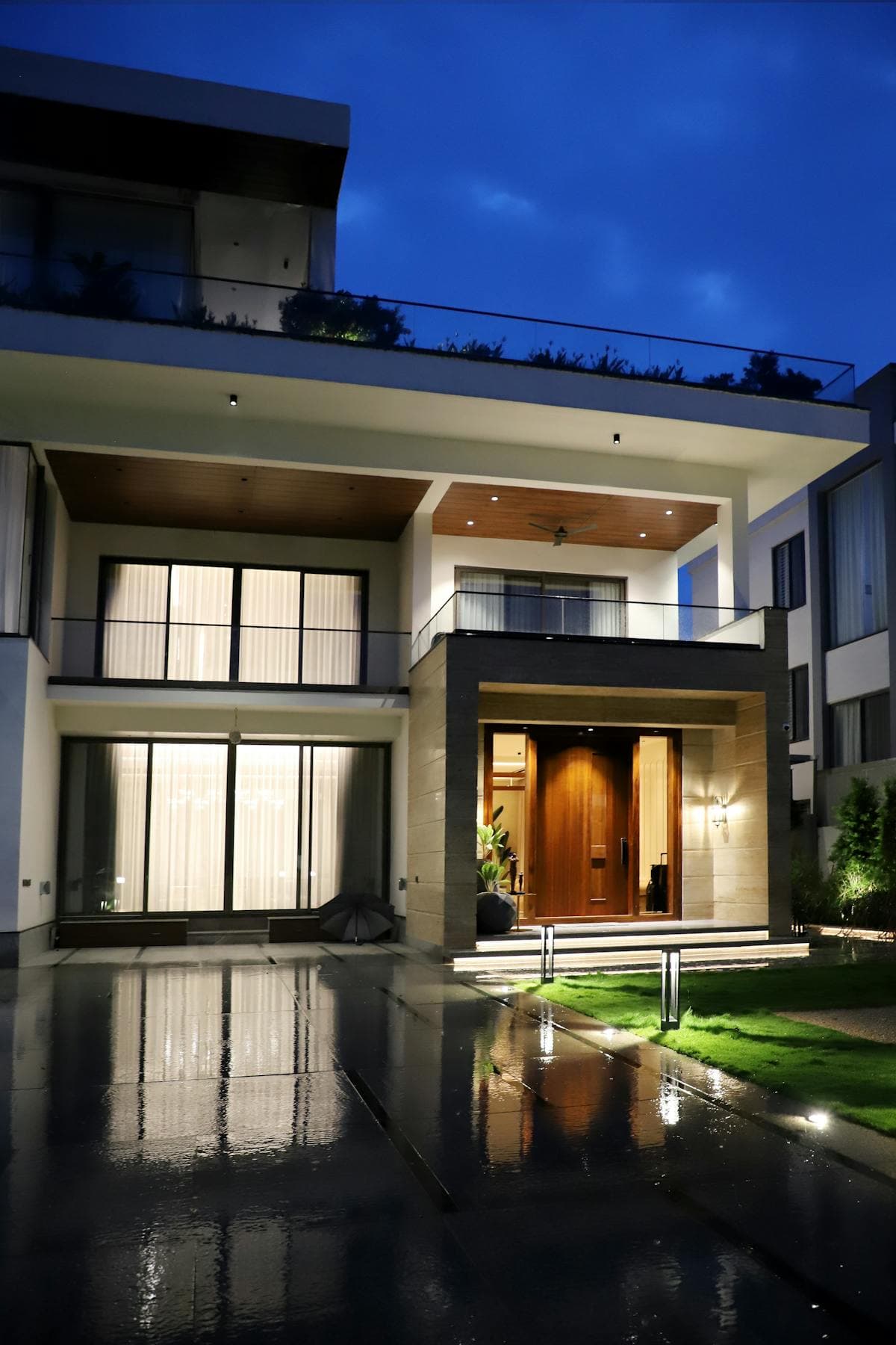 Modern home with energy-efficient permanent LED outdoor lighting illuminating the exterior at dusk