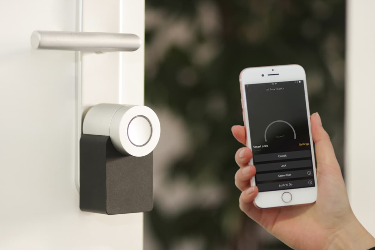 Sacramento homeowner using a smartphone app to control permanent outdoor LED lights on a house exterior at dusk